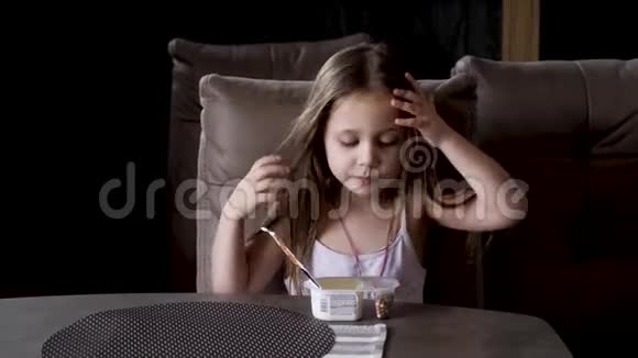 坐在桌子旁吃酸奶的小女孩儿童食品视频的预览图