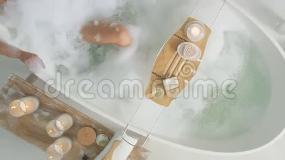 性感的女人在家洗澡放松的女孩躺在浴缸里用泡沫视频的预览图