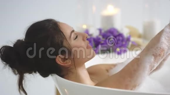特写的黑发女人用泡沫洗手优雅的女孩洗澡放松视频的预览图