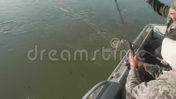 白人渔夫钓到了大的萨赞用鱼竿把它拉进船里上景视频的预览图