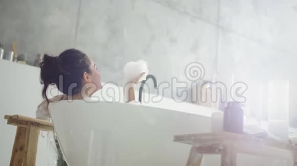 特写开朗的女人吹泡沫在轻浴室IMN慢动作视频的预览图