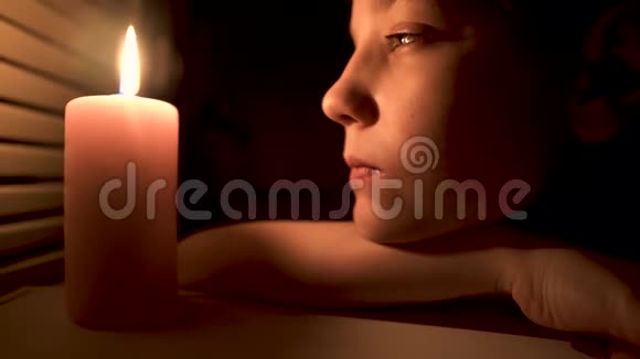 男孩看着一支燃烧的蜡烛然后男孩吹灭了蜡烛视频的预览图