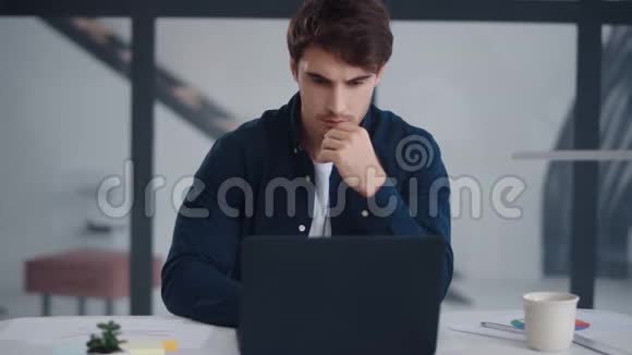 专注的商人在办公室工作笔记本电脑他在笔记本上读课文视频的预览图