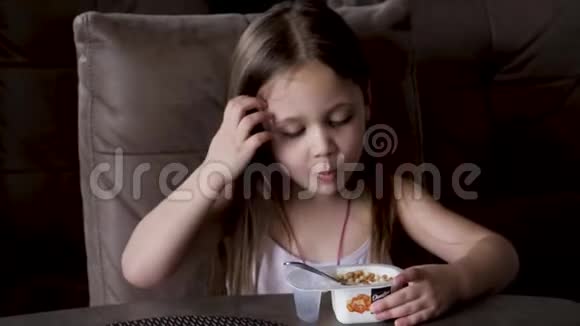 女孩坐在桌子旁吃酸奶孩子们早餐视频的预览图