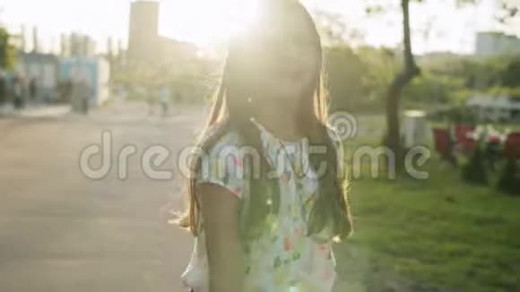 快乐的少女跳出去在公园里做有节奏动作的女孩视频的预览图