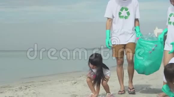 快乐的亚洲家庭团队志愿者在海滩上清洁垃圾和塑料瓶以减少污染和有毒视频的预览图