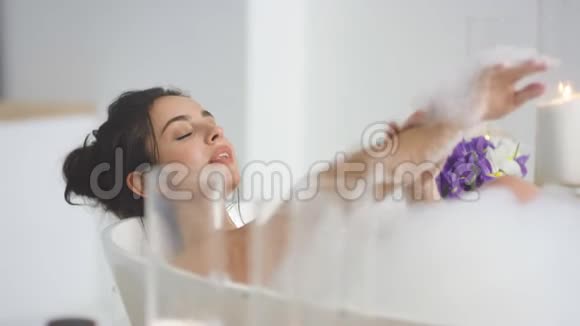 特写微笑的女人用泡沫洗手性感的女人放松的浴缸视频的预览图