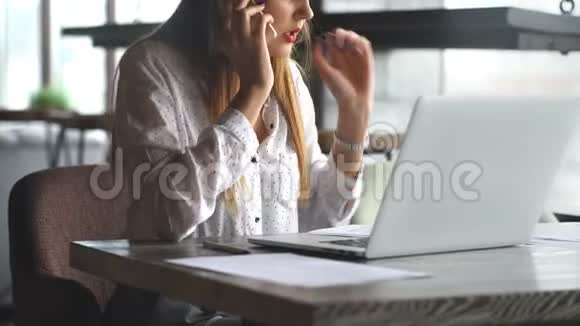 女商人用手提电脑和手机聊天视频的预览图