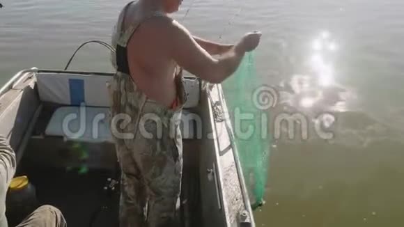 白渔夫挂着绿网和大鱼出海男人爱好一大早视频的预览图