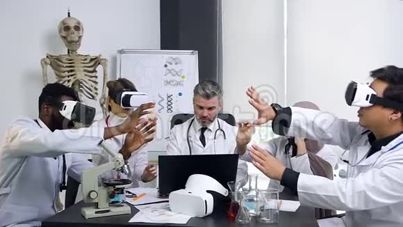 自信的经验丰富的身穿白色长袍的首席医生与使用增强现实眼镜和视频的预览图