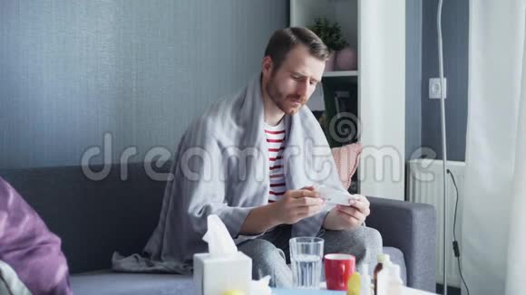 一个成年病人坐在沙发上用水吃药视频的预览图