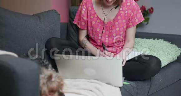 幸福的女人戴着耳机通过电话会议通话在家看电脑视频聊天工作面试或视频的预览图