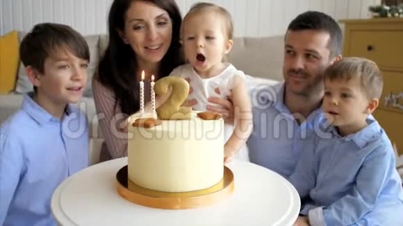 可爱的小女孩在生日蛋糕上吹蜡烛视频的预览图