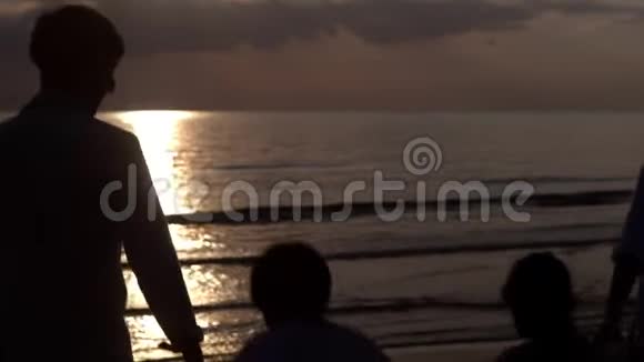 亚洲家庭幸福的剪影晚上和日落一起在海滩上跑步放松视频的预览图