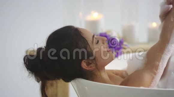 关闭放松的女人接触皮肤泡沫Brunette女浴视频的预览图