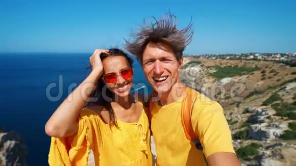 可爱的一对游客在悬崖边自拍和微笑美丽的海景和享受美妙视频的预览图