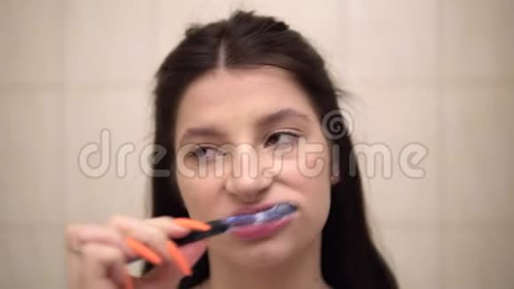 年轻女子刷牙感觉强烈牙痛抚摸脸颊特写视频的预览图