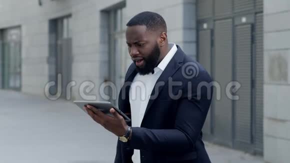 商人看着街上的平板电脑屏幕非洲裔男子使用户外垫视频的预览图