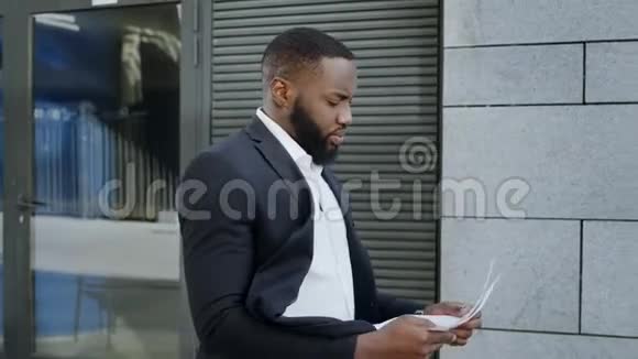 非洲商人在街上阅读文件员工到户外工作视频的预览图
