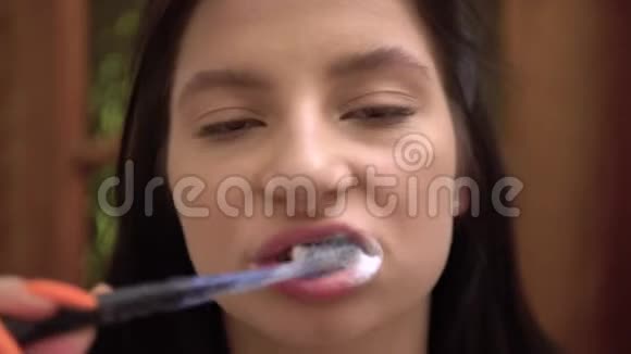 年轻女子用牙膏刷牙健康的牙齿口腔卫生视频的预览图
