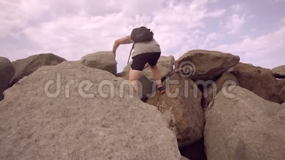 一个旅行者慢慢地上升到悬崖的顶端视频的预览图