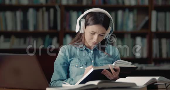 图书馆阅读耳机的女学生视频的预览图