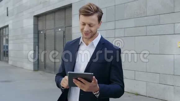 商人在城市的平板电脑上浏览互联网员工在街上使用便笺视频的预览图