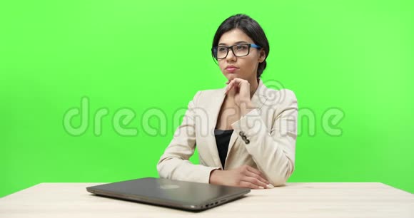 体贴的商务女性坐在办公桌前拿着笔记本电脑视频的预览图