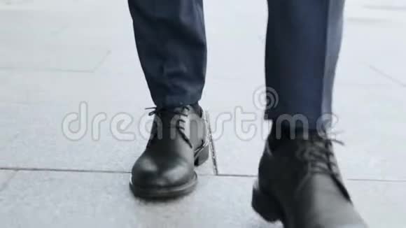 商人们在城市大街上散步穿黑色皮鞋的企业家视频的预览图