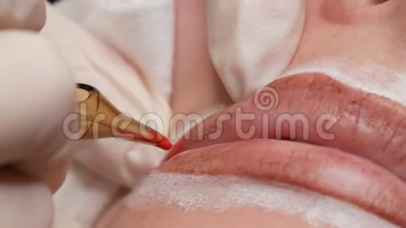 永久化妆嘴唇程序双手戴乳胶手套一位熟练的美容师用颜料化妆嘴唇视频的预览图