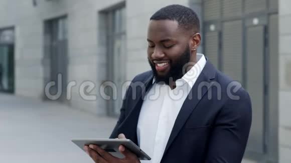 非洲商人在街上的平板电脑上打字工人在户外使用垫子视频的预览图