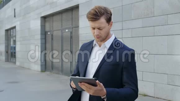 商人在城市里做数字平板电脑经理浏览网页视频的预览图