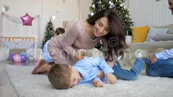 快乐的妈妈正在地板上逗她的小笑儿子特写镜头视频的预览图