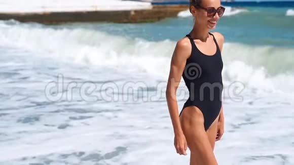 慢镜头肖像苗条美丽微笑的女人穿着泳装站在海边的水上视频的预览图