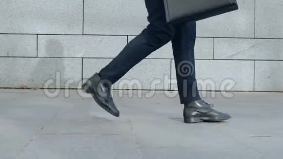 商人的腿在城市街道上跳跃男性职业舞蹈在街头视频的预览图