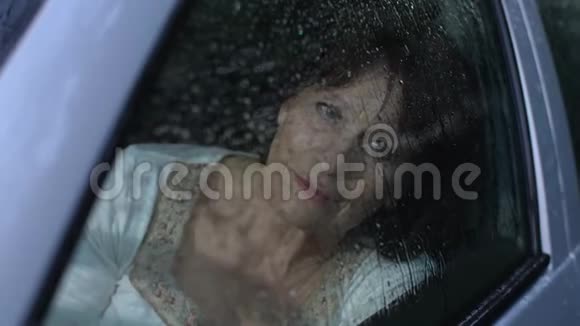 坐在车里的女人看着雨视频的预览图