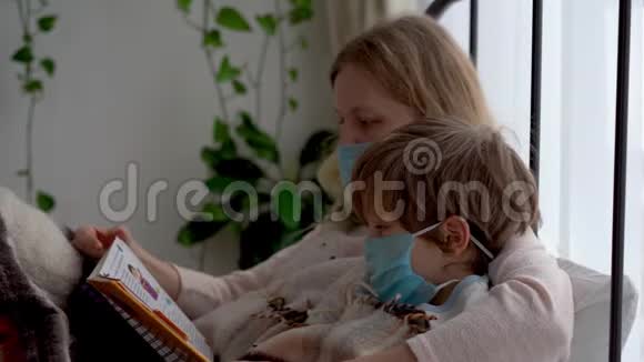 冠状病毒流行的检疫受感染的蒙面母亲和小儿子正在卧室的床上休息视频的预览图