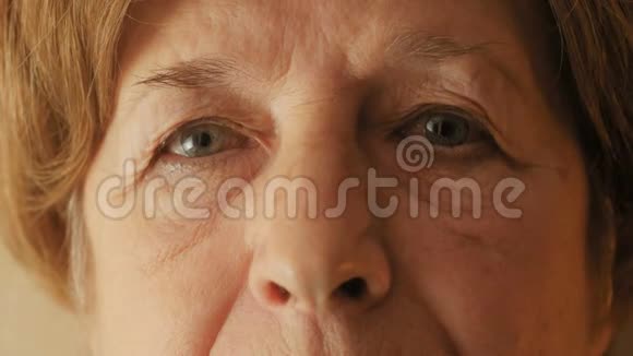 脸上的一个老妇人直接看着镜头特写奶奶眼睛看着你年龄观念和人视频的预览图