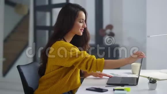 快乐商务女性完成笔记本电脑的工作漂亮的女孩关闭电脑视频的预览图