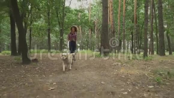 那个女孩和一只狗在森林里奔跑视频的预览图