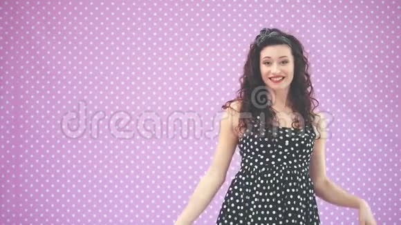 可爱的小女孩一头古怪的头发穿着黑色圆点花裙跳舞滑稽地挥动着她的手指着复制空间视频的预览图