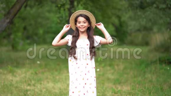 微笑女孩在花园的绿色自然中轻拍视频的预览图