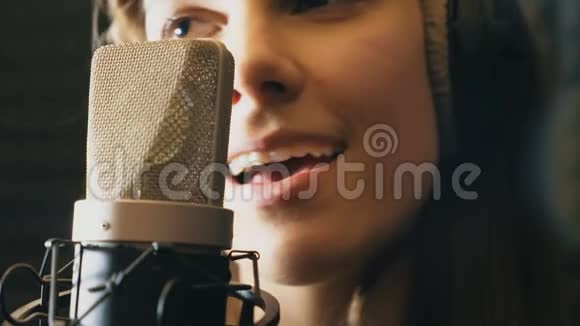 美丽的女孩在录音室唱歌享受过程年轻歌手有感情地录制新歌女士唱歌视频的预览图