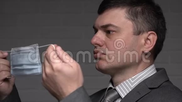 一个男人在脸上戴上防毒面具个人防护医疗保健和医学概念预防技巧视频的预览图