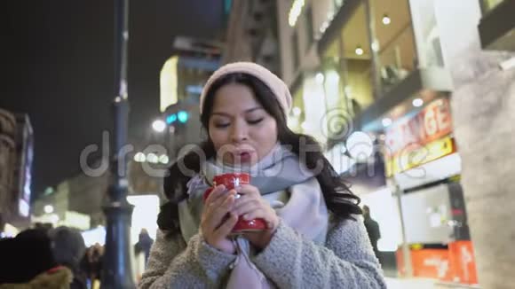 亚洲黑发女人在城市生活背景下喝热咖啡视频的预览图