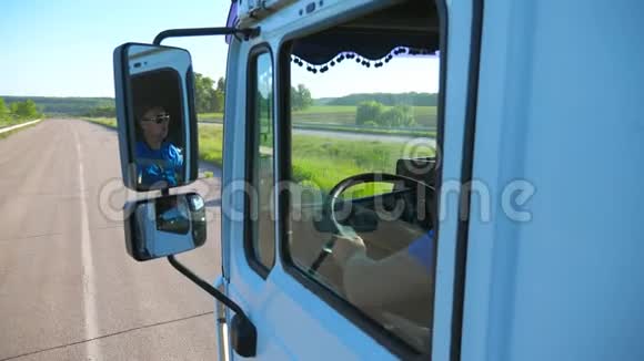 卡车司机戴着太阳镜在移动汽车的侧面镜子里反射男子驾驶卡车通过视频的预览图