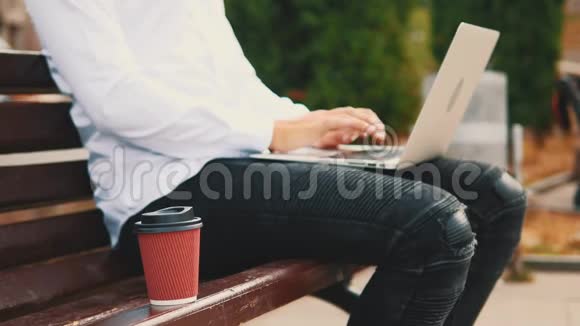 作物商人穿着商业风格坐在公园里的户外在笔记本电脑上打字视频的预览图