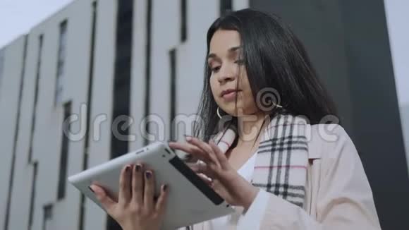 女商人在数字平板电脑上读好消息在户外使用触摸板的女孩视频的预览图