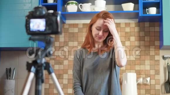 食品博客女孩影响者正在厨房录制视频或播客制作生活博客vlog显示ok标志视频的预览图