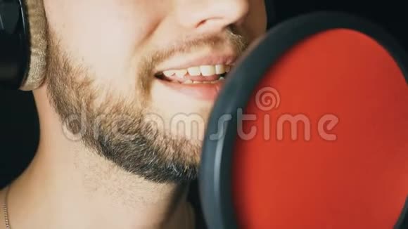 男歌手在录音室唱歌的嘴无法辨认的人录制新歌有胡子的人唱麦克风视频的预览图